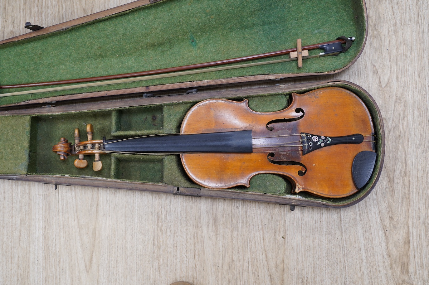 A late 19th century German violin, bearing a Stradivarius label, dated 1717, with mother of pearl inlaid tailpiece, in a walnut case and with bow, the bow stamped Vuillaume & Paris. Condition - fair